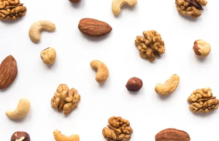 بادام، فندق، گردو و بادام هندی چیده شده روی میز