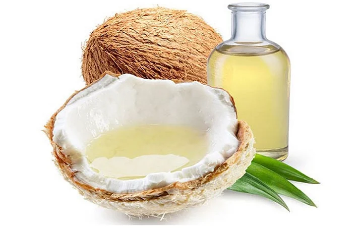 یک بطری روغن نارگیل در کنار خود این میوه